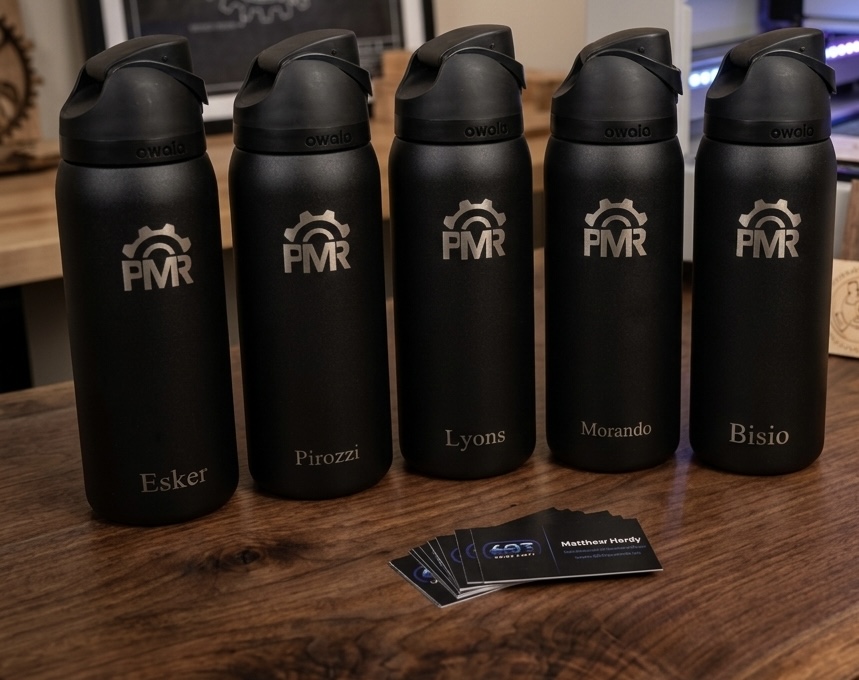 Five black Owala water bottles engraved with the PMR logo and team member names