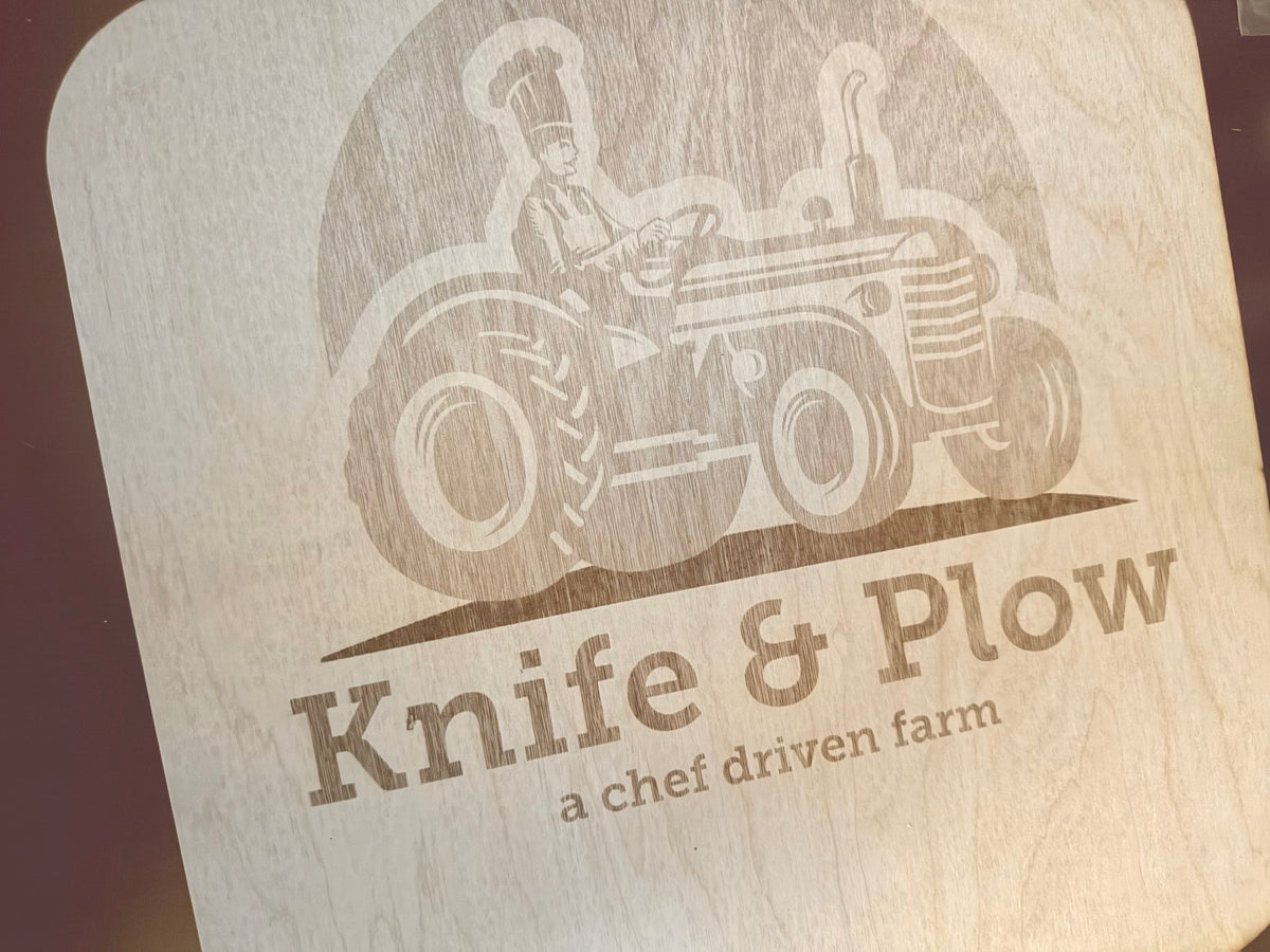 Wood cutting board engraved with a farm logo